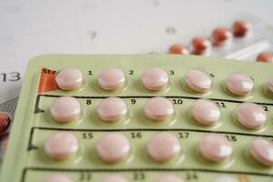 Birth control pills for female on calendar, ovulation day. photo