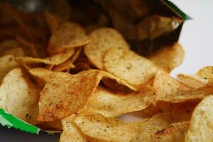 papas fritas en bolsa abierta, delicioso condimento de barbacoa picante para crips, refrigerio frito en rodajas finas comida rápida en bolsa abierta. foto