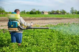 kherson oblast, Ucrania - mayo 22, 2021 granjero aerosoles un patata plantación con un pulverizador. niebla pulverizador, fungicida y pesticida. cosecha proteccion de cultivado plantas en contra insectos y hongos foto