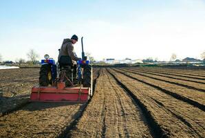 Kherson oblast, Ukraine - November 12, 2021 Senior farmer cultivating the field soil. Seasonal worker. Recruiting workers for work on agricultural machinery. Farming. Small farms. Rural scene photo