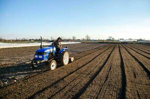 Kherson oblast, Ukraine - November 12, 2021 Tractor cultivating the farm field. Farming. preparing for cutting rows for the next sowing season in the spring. Softening and improving soil qualities. photo