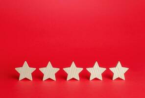 Five stars on a red background. Rating evaluation concept. Service quality feedback. High satisfaction. Good reputation. Popularity rating of restaurants, hotels or mobile applications. Highest score photo