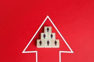 Business team group of people made of blocks in the direction arrow. Teamwork. Movement in a single group. Consolidation into a larger formation. Common interest, joint problem solving. photo