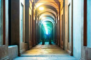 Bologna,Italy- June 23, 2023-People stroll at night under the arcades leading to the sanctuary of San Luca illuminated for the first edition of the Bologna arcades Festival. photo