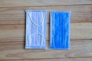 Two pieces of blue Sanitary mask on wooden background, medical mask, medical protective mask, blue surgical mask, Face mask for corona virus protection covid-19 . photo