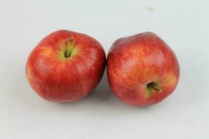 jugoso rojo manzanas, en pie solo en un prístino blanco lienzo. de la naturaleza tentación en un vibrante mostrar. foto