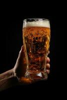 a male hand holding up a glass of beer isolated on a black background. ai generated photo