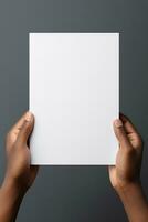 A human hand holding a blank sheet of white paper or card isolated on grey background. ai generated photo