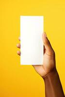 A human hand holding a blank sheet of white paper or card isolated on yellow background. ai generated photo