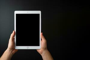 Hand holding tablet with mockup blank screen isolated on black background with copy space. ai generated photo