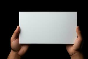 A human hand holding a blank sheet of white paper or card isolated on black background. ai generated photo