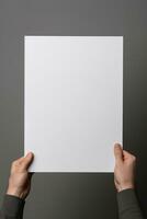 A human hand holding a blank sheet of white paper or card isolated on grey background. ai generated photo