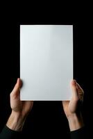 A human hand holding a blank sheet of white paper or card isolated on black background. ai generated photo