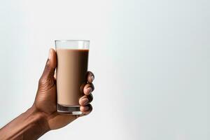 Hand holding a glass of delicious chocolate milk isolated on white background with copy space. ai generated photo