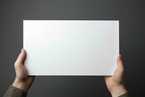 A human hand holding a blank sheet of white paper or card isolated on grey background. ai generated photo