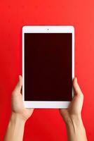 Hand holding tablet with mockup blank screen isolated on red background. ai generated photo