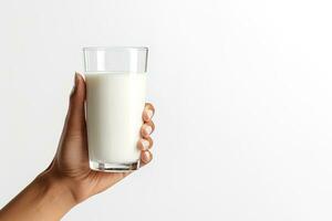 Hand holding a glass of fresh milk isolated on grey background with copy space. ai generated photo