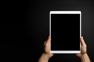 Hand holding tablet with mockup blank screen isolated on black background with copy space. ai generated photo