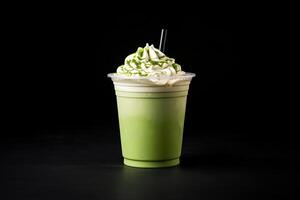 verde té frappucino con azotado crema en un para llevar taza aislado en oscuro antecedentes. ai generado foto