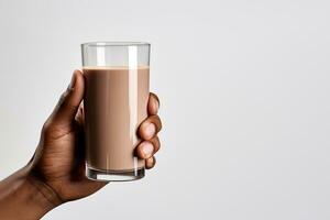 Hand holding a glass of delicious chocolate milk isolated on white background with copy space. ai generated photo