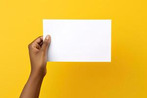 A human hand holding a blank sheet of white paper or card isolated on yellow background. ai generated photo