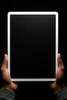 Hand holding tablet with mockup blank screen isolated on black background. ai generated photo