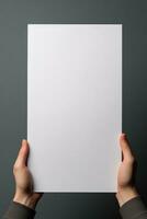 A human hand holding a blank sheet of white paper or card isolated on grey background. ai generated photo