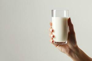 mano participación un vaso de Fresco Leche aislado en gris antecedentes con Copiar espacio. ai generado foto