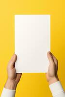 A human hand holding a blank sheet of white paper or card isolated on yellow background. ai generated photo