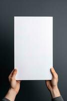 A human hand holding a blank sheet of white paper or card isolated on grey background. ai generated photo