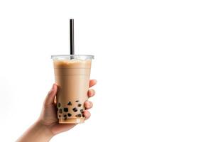 A hand holding takeaway plastic cup of delicious iced bubble milk tea and black pearls isolated on white background with copy space. ai generated photo