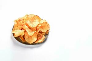 Crispy fried potato chips on a plate isolated on a white background with copy space. ai generated photo