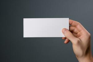 A human hand holding a blank sheet of white paper or card isolated on grey background. ai generated photo