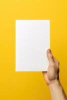 un humano mano participación un blanco sábana de blanco papel o tarjeta aislado en amarillo antecedentes. ai generado foto