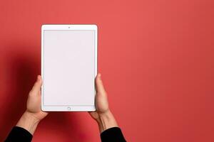 Hand holding tablet with mockup blank screen isolated on red background with copy space. ai generated photo