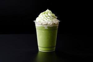 Green tea frappucino with whipped cream in a takeaway cup isolated on dark background. photo