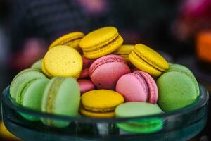 a glass bowl filled with colorful macarons photo