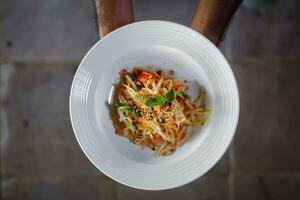 a plate of food is held in the hands of a person photo