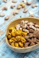 a wooden bowl filled with nuts and cashews photo