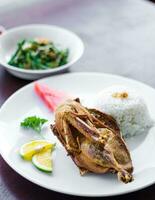 A plate of traditional seasoned crispy duck on a table photo