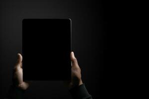 Hand holding tablet with mockup blank screen isolated on black background with copy space. ai generated photo