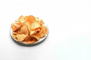 Crispy fried potato chips on a plate isolated on a white background with copy space. ai generated photo