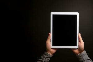 Hand holding tablet with mockup blank screen isolated on black background with copy space. ai generated photo