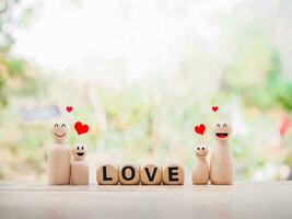Wooden figure of the family and wooden block with word the LOVE. The concept of romantic feelings, family relationship. photo