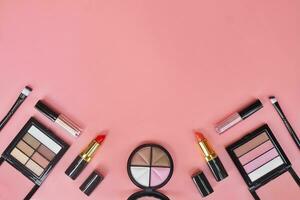 Set of makeup cosmetic accessories on pink background. photo