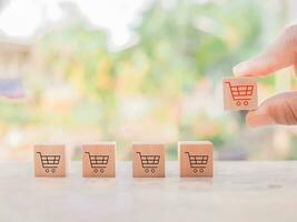 cerca arriba mano escoger de madera bloquear con rojo compras carro íconos para en línea compras y comercio electrónico concepto foto