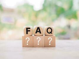 Wooden block with word the FAQ with question marks. The concept of question or answer time. photo