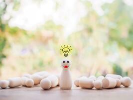 Wooden business figure with light bulb for leadership, creative, idea, innovation concept. photo