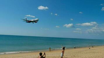 phuket, Tailandia febrero 05, 2023 - lento movimiento, boeing 767 de azur aire aterrizaje terminado mar y playa a phuket aeropuerto. turistas personas ven a tomar foto y selfie de el avión moscas video