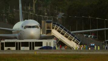 PHUKET, THAILAND FEBRUARY 4, 2023 - Passengers get off the emergency aircraft of Azur Air and go to the apron bus. Engine fire incident during takeoff. Aborted flight. Passenger evacuation video